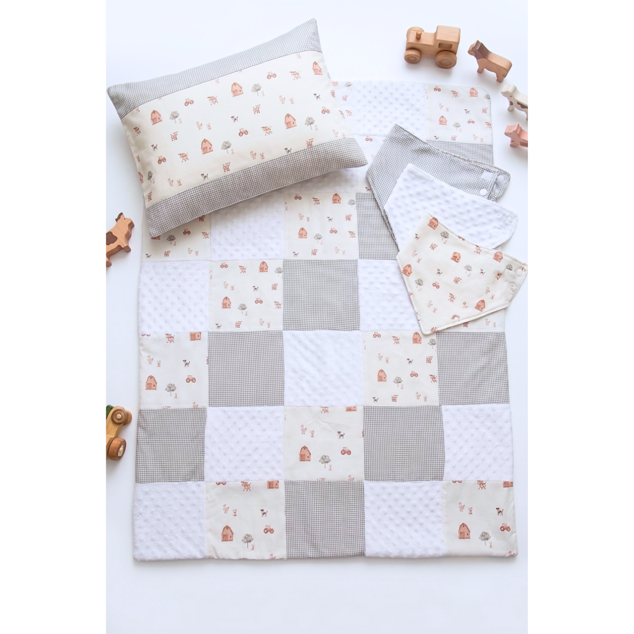 Farm Friends patchwork baby quilt with matching pillowcase and bandana bibs flat lay