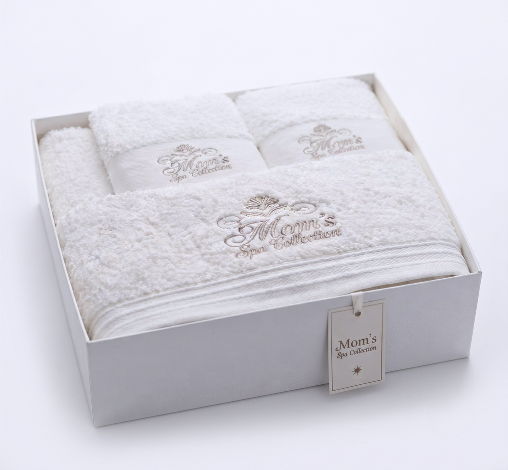 Close-up of Mom's Spa Collection champagne embroidery on plush white towels