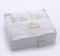 Close-up of Mom's Spa Collection champagne embroidery on plush white towels