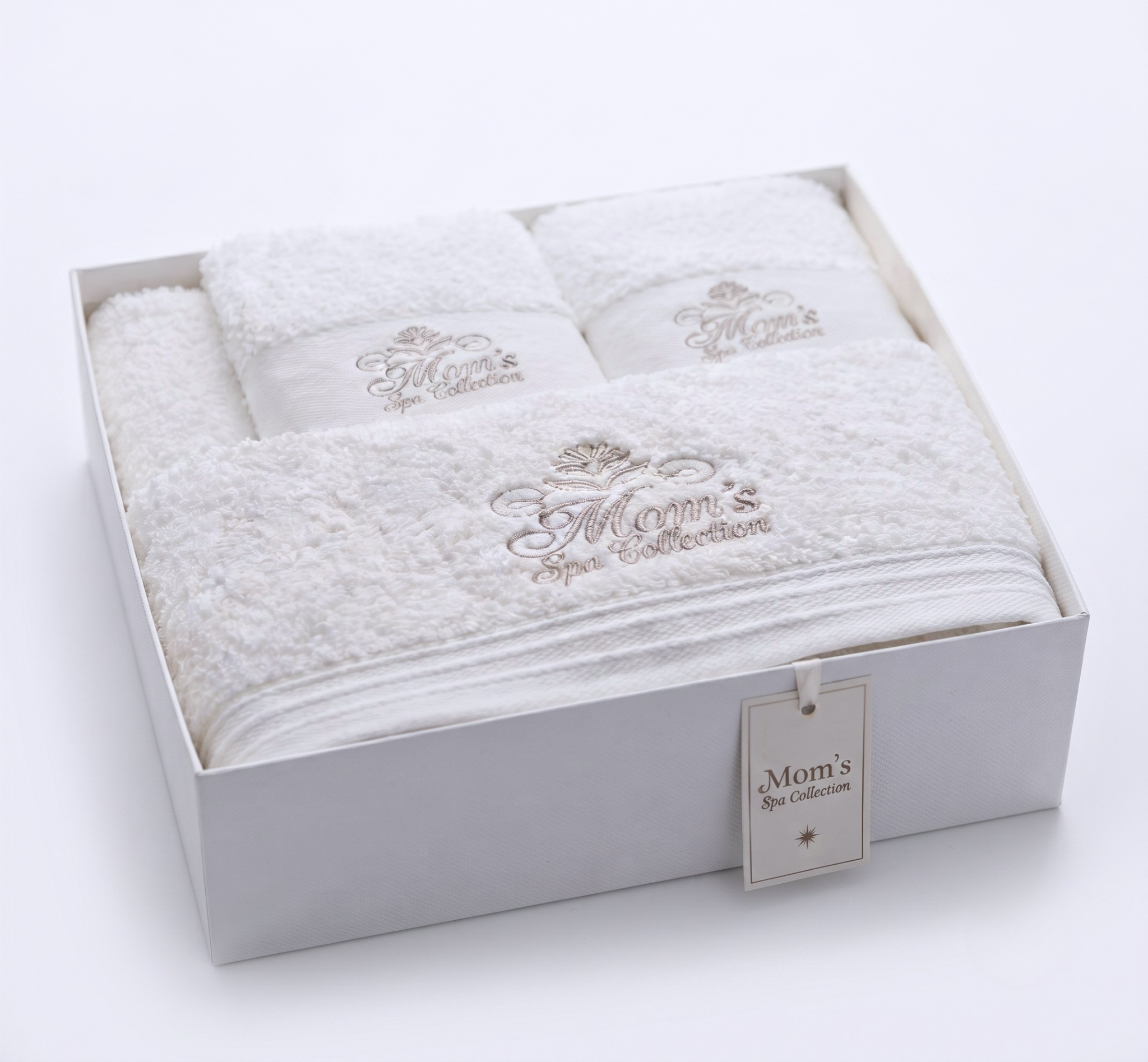 Close-up of Mom's Spa Collection champagne embroidery on plush white towels