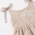 Muslin Baby Dress Claire Soft Handmade Clothing with floral embroidery and tie straps in soft beige muslin fabric.