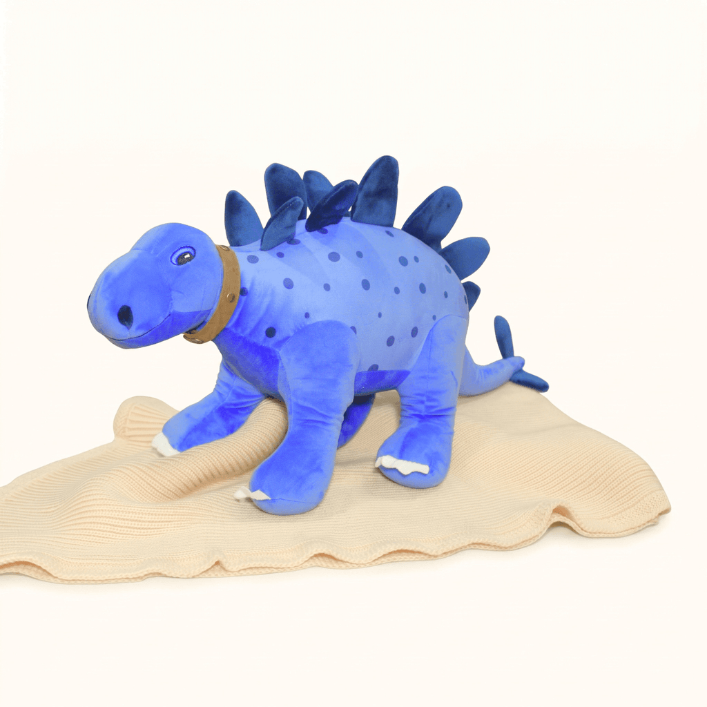 Lexi Personalised Baby Name Dinosaur plush toy in royal blue on a beige blanket.