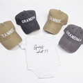 Guess What New Parents Announcement Cap Gift Box featuring caps for grandparents and a onesie with Guess what?! design.