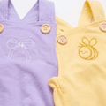 Embroidered Cotton Baby Romper featuring a white bow and a golden bee on lavender and yellow backgrounds.